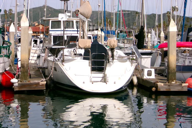 Slide: The Image of 1994 Hunter Legend 40 sailboat docked in a marina with scenic mountain backdrop. - 5