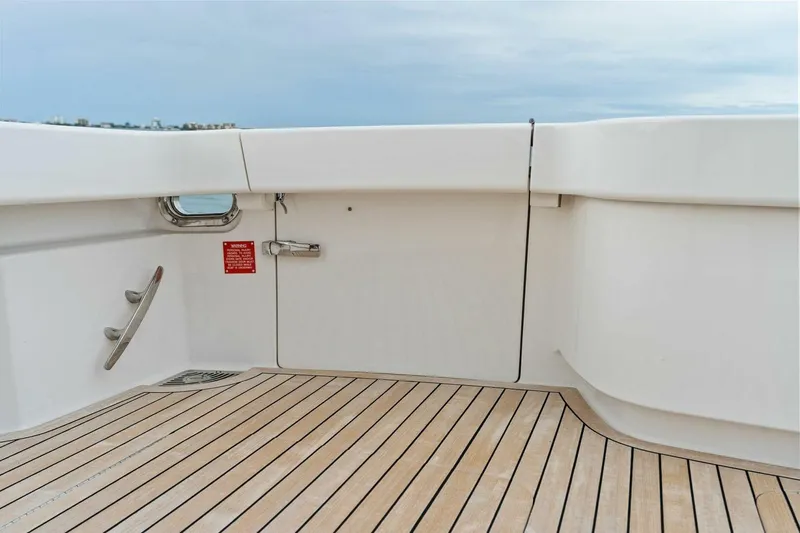 Slide: The Image of 2021 Viking 46 Billfish yacht deck with sleek white finish and wooden flooring. - 22