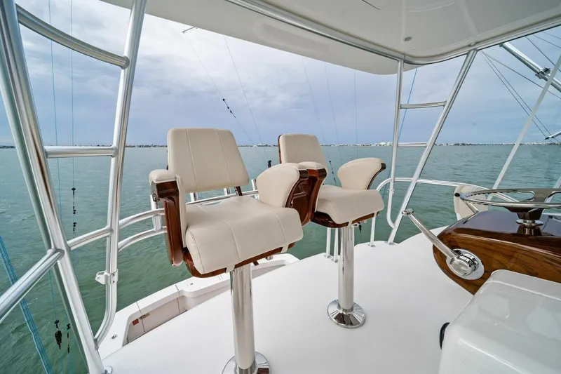 Slide: The Image of 2021 Viking 46 Billfish yacht helm with two white captain chairs overlooking the ocean. - 33