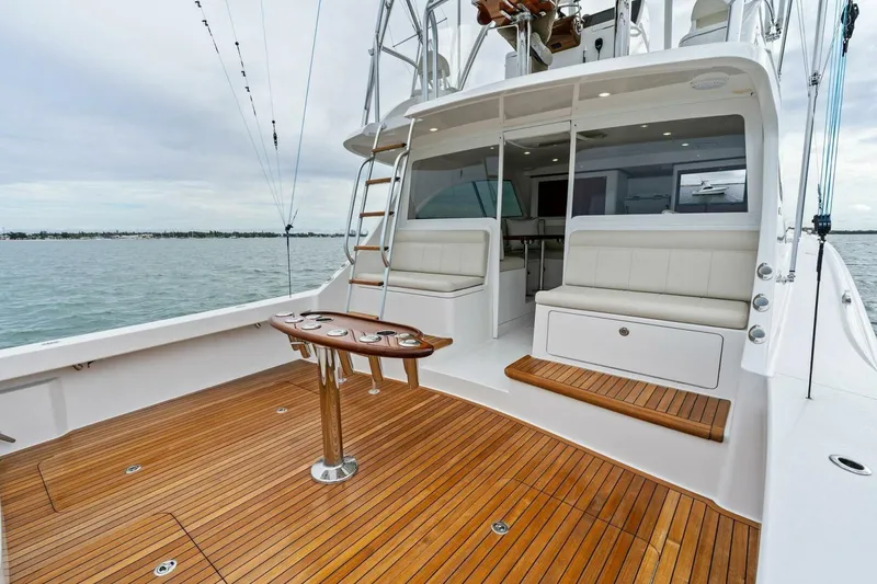 Slide: The Image of 2021 Viking 46 Billfish yacht with teak deck and seating area, docked on calm waters. - 42