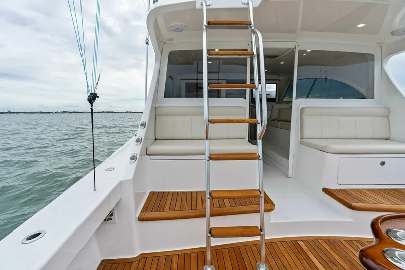 Slide: The Image of 2021 Viking 46 Billfish yacht interior with wooden steps and seating, overlooking the ocean. - 44