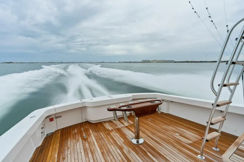 Slide: The Image of 2021 Viking 46 Billfish yacht cruising, showcasing teak deck and fishing setup. - 48