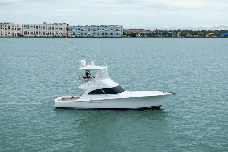 Slide: The Image of 2021 Viking 46 Billfish yacht on calm water with cityscape background. - 85