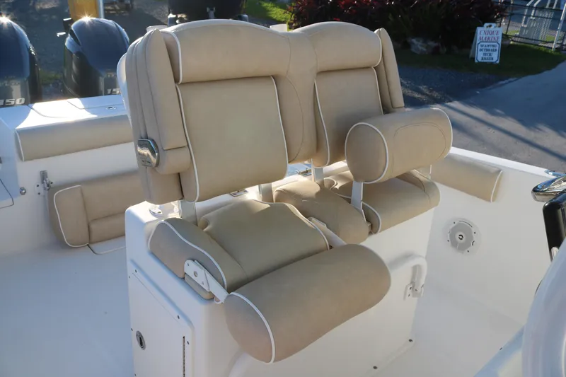 Slide: The Image of 2016 Sea Hunt Gamefish 25 boat seating with beige upholstery and dual outboard motors. - 8