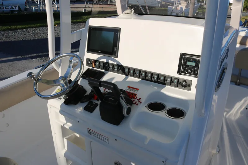 Slide: The Image of 2016 Sea Hunt Gamefish 25 boat console with steering wheel and electronic controls. - 9