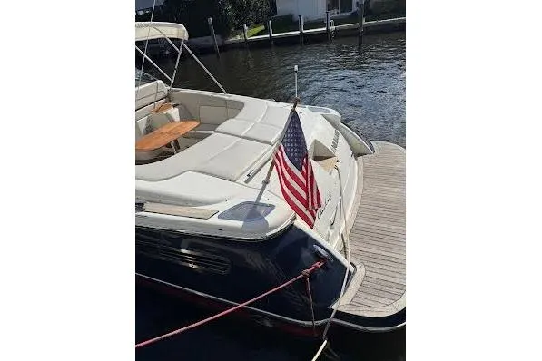 Slide: The Image of 2006 Chris Craft Corsair Heritage boat with American flag, docked by the water. - 10