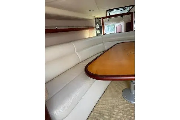 Slide: The Image of 2006 Chris Craft Corsair Heritage interior with triangular wooden table and white seating. - 21