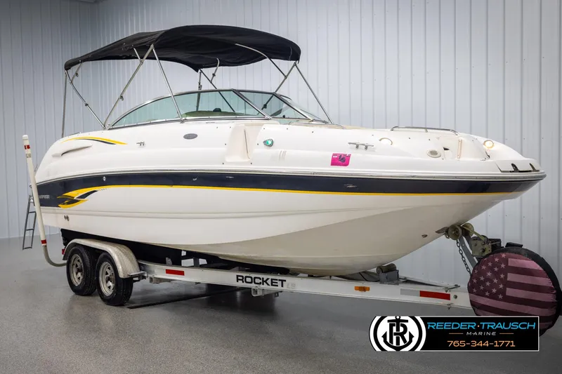 Slide: The Image of Chaparral 243 Sunesta 2002 boat on trailer with canopy in indoor showroom. - 3
