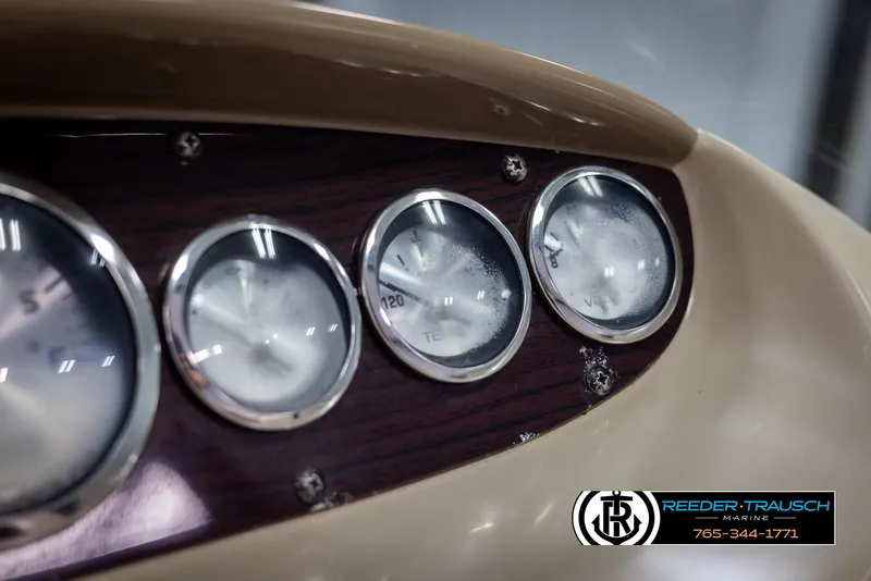 Slide: The Image of Dashboard gauges of a 2002 Chaparral 243 Sunesta boat, featuring a wood panel design. - 30