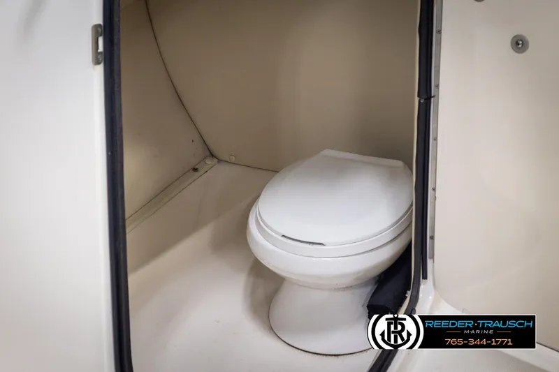 Slide: The Image of Interior of 2002 Chaparral 243 Sunesta boat featuring a compact marine toilet. - 38