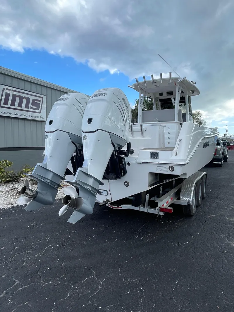 Slide: The Image of 2014 Everglades 325 Center Console boat with dual outboard engines on a trailer. - 18