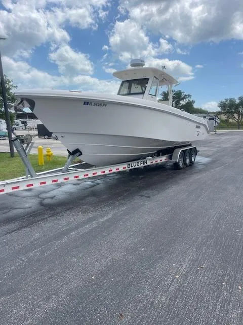 Slide: The Image of 2014 Everglades 325 Center Console boat on trailer, parked on asphalt under cloudy sky. - 32