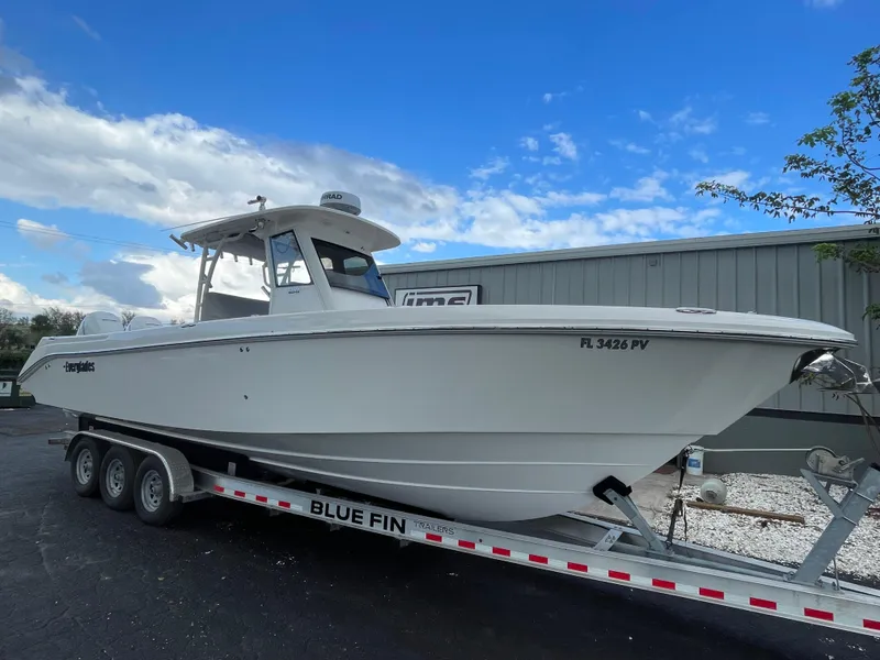 Slide: The Image of 2014 Everglades 325 Center Console boat on trailer, parked outdoors. - 4