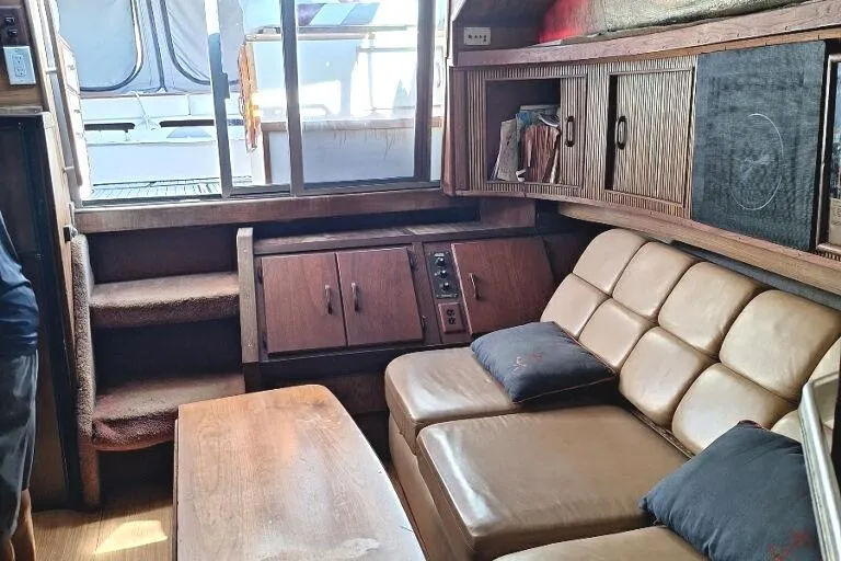 Slide: The Image of Interior of 1985 Sea Ray 390 Express Cruiser with leather seating and wooden cabinetry. - 12
