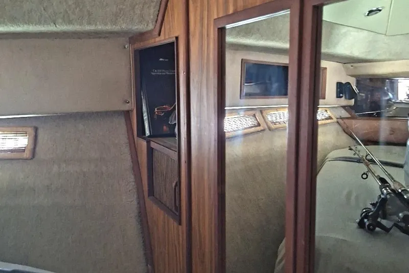Slide: The Image of Interior of 1985 Sea Ray 390 Express Cruiser with wood paneling and fishing rods. - 15
