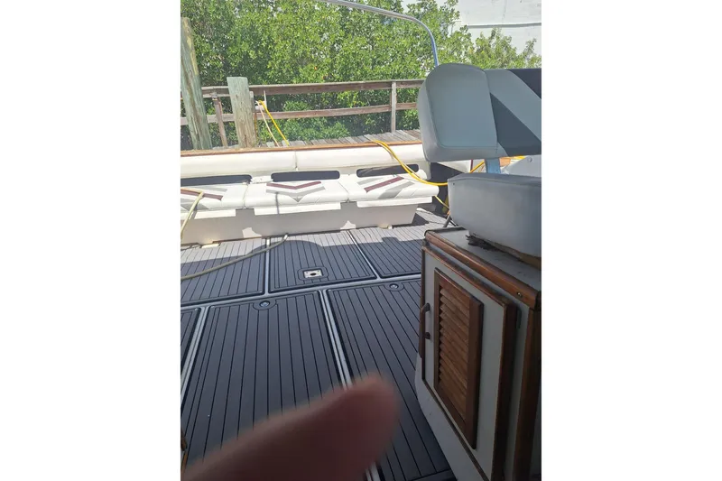 Slide: The Image of 1985 Sea Ray 390 Express Cruiser interior with seating and wooden cabinetry. - 23