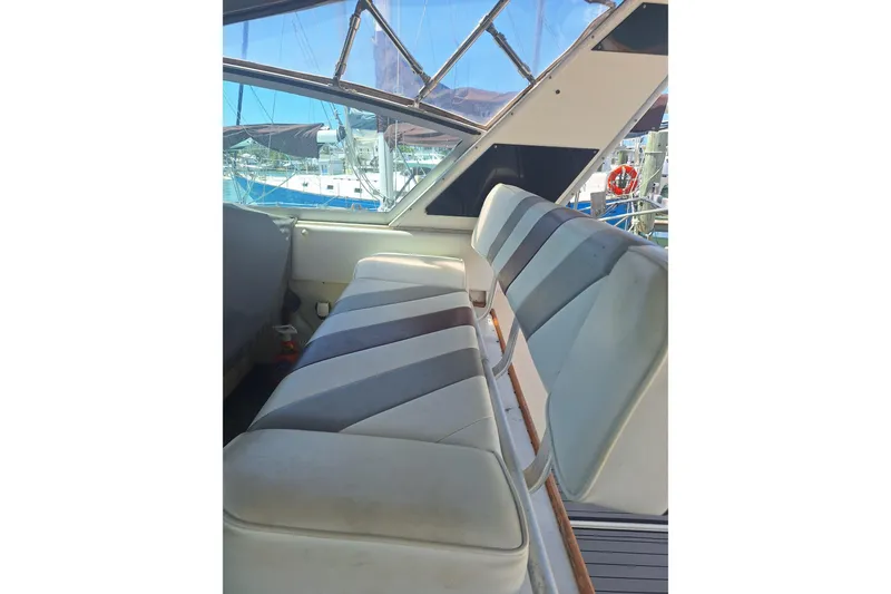 Slide: The Image of 1985 Sea Ray 390 Express Cruiser interior with striped seating and marina view. - 24