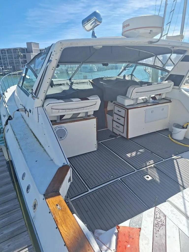 Slide: The Image of 1985 Sea Ray 390 Express Cruiser docked, featuring spacious deck and seating area. - 3