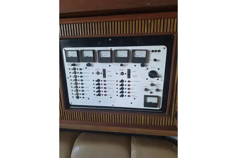 Slide: The Image of 1985 Sea Ray 390 Express Cruiser interior with beige sofa and wooden table. - 5
