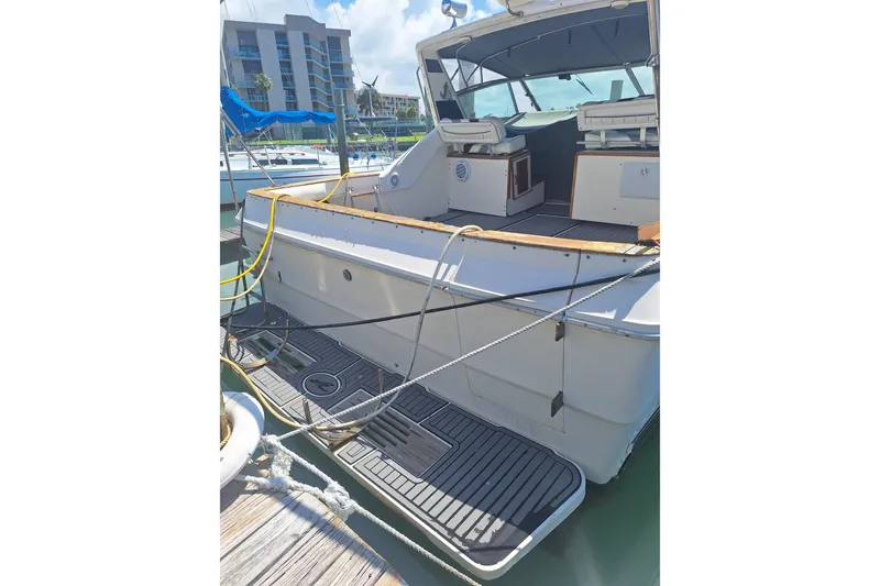 Slide: The Image of 1985 Sea Ray 390 Express Cruiser docked, showcasing spacious deck and seating area. - 8