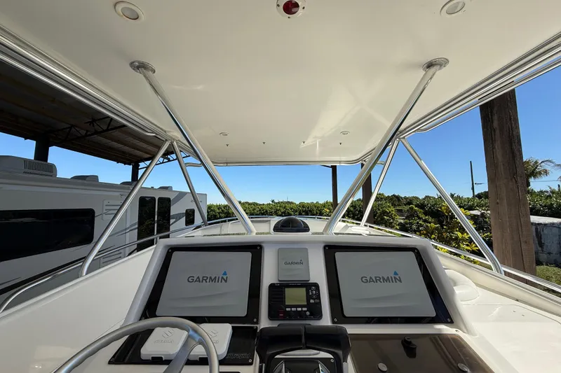 Slide: The Image of 2008 Intrepid 377 Walkaround boat helm with Garmin navigation displays under a canopy. - 105