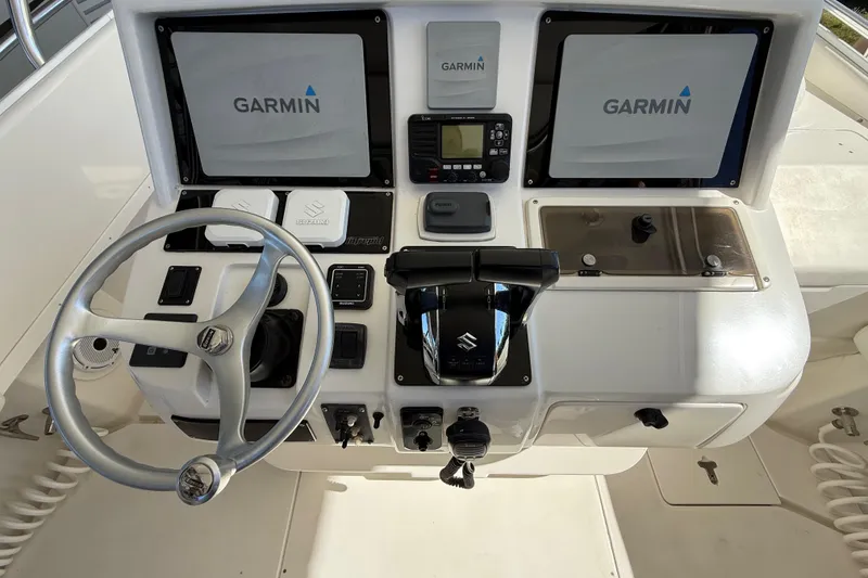 Slide: The Image of 2008 Intrepid 377 Walkaround boat dashboard with Garmin displays and Suzuki controls. - 107