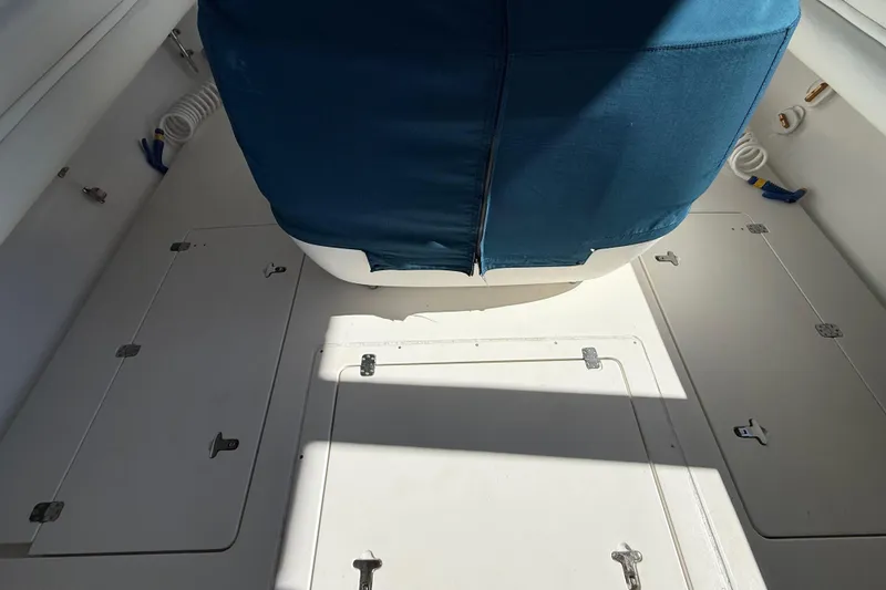 Slide: The Image of 2008 Intrepid 377 Walkaround boat interior with blue seat cover and storage compartments. - 109