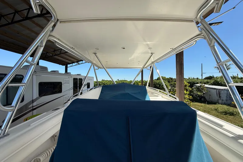 Slide: The Image of 2008 Intrepid 377 Walkaround boat with covered seating, parked near RVs and greenery. - 113