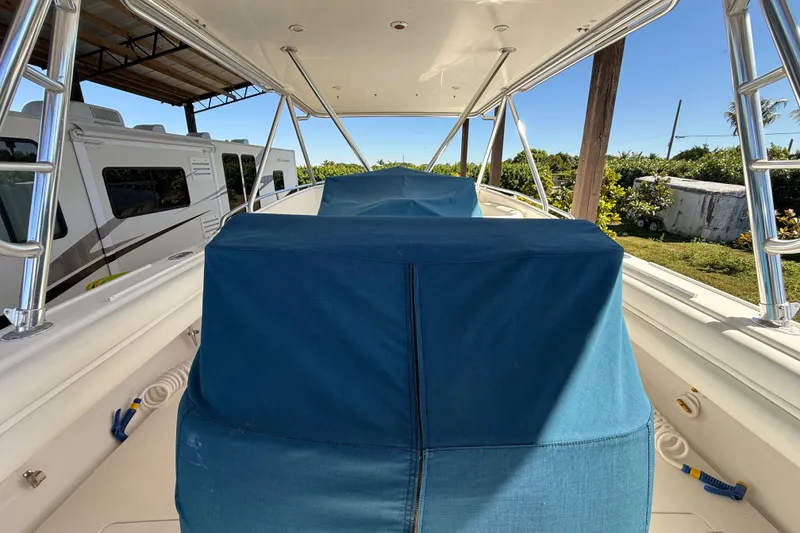 Slide: The Image of 2008 Intrepid 377 Walkaround boat with blue covers, parked near RVs and greenery. - 114