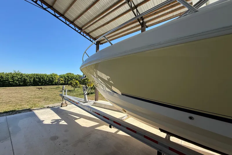 Slide: The Image of 2008 Intrepid 377 Walkaround boat on trailer under a metal roof, sunny day. - 12