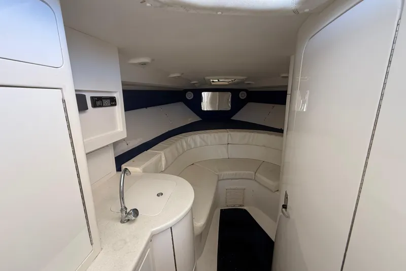 Slide: The Image of 2008 Intrepid 377 Walkaround cabin interior with white seating and compact kitchenette. - 133