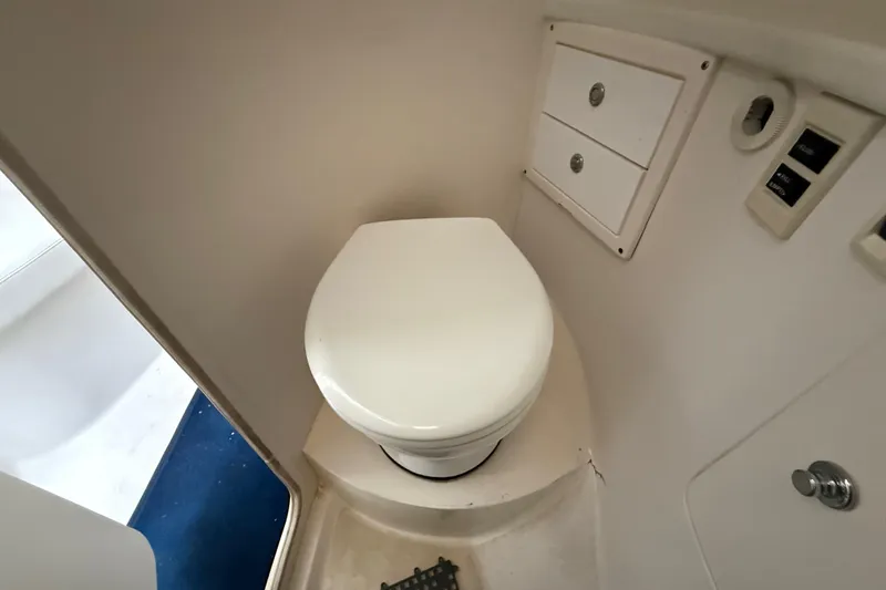 Slide: The Image of 2008 Intrepid 377 Walkaround boat bathroom with toilet and storage compartments. - 140