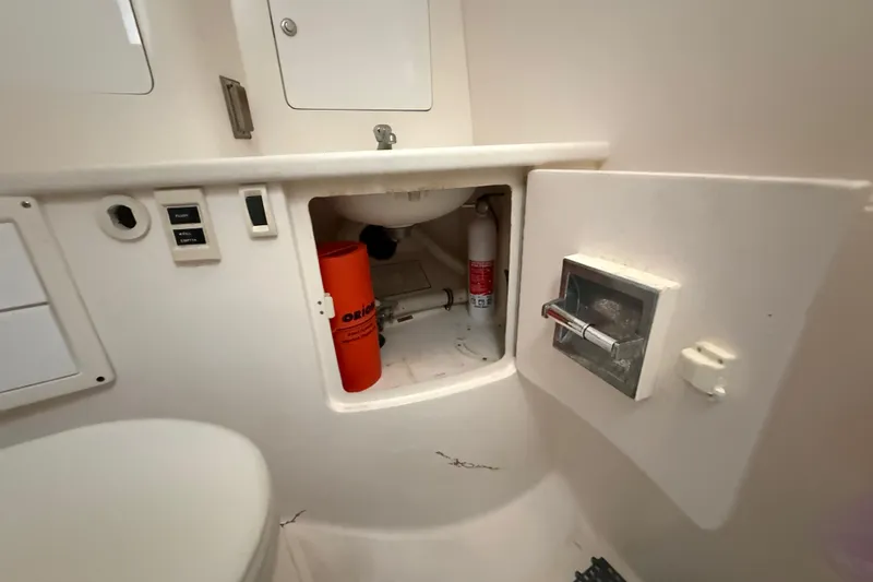 Slide: The Image of 2008 Intrepid 377 Walkaround bathroom storage with safety equipment and fire extinguisher. - 143