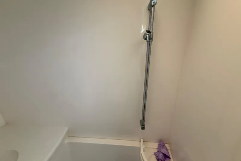 Slide: The Image of Shower area inside 2008 Intrepid 377 Walkaround boat, featuring a mounted showerhead. - 146