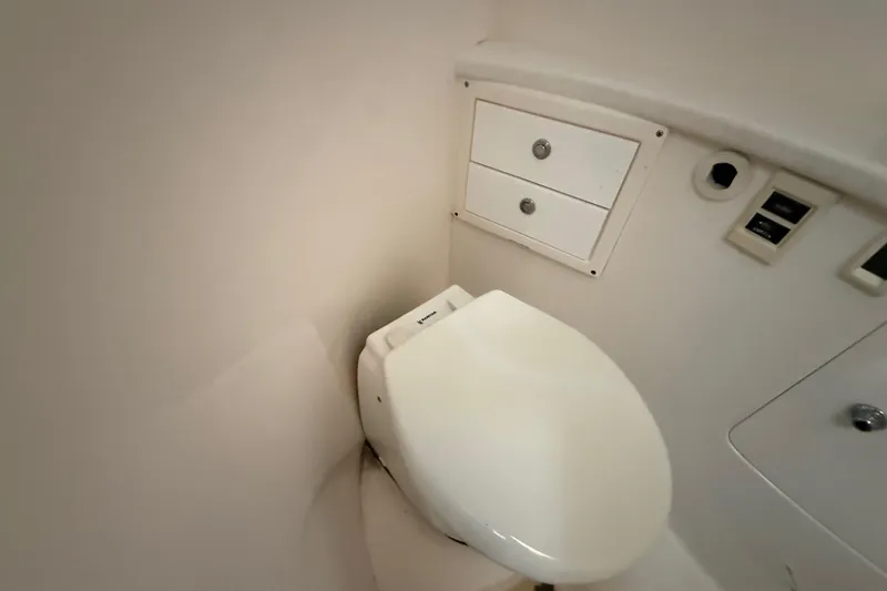 Slide: The Image of 2008 Intrepid 377 Walkaround boat bathroom with toilet and storage drawers. - 152