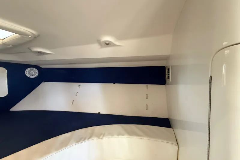 Slide: The Image of Interior cabin of a 2008 Intrepid 377 Walkaround boat, featuring white and blue upholstery. - 165