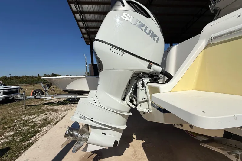 Slide: The Image of 2008 Intrepid 377 Walkaround with Suzuki outboard motor, parked under a metal roof. - 32