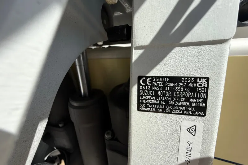 Slide: The Image of Label on Suzuki motor, 2023, showing specifications and European liaison office details. - 35