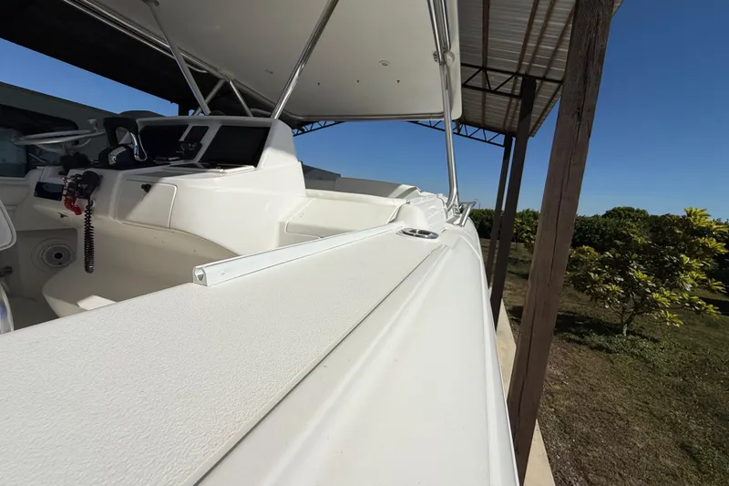 Slide: The Image of 2008 Intrepid 377 Walkaround boat under a canopy, showcasing sleek design and helm area. - 38