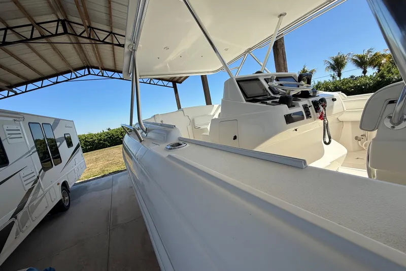 Slide: The Image of 2008 Intrepid 377 Walkaround boat under a canopy, next to a parked RV. - 39