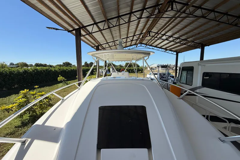 Slide: The Image of 2008 Intrepid 377 Walkaround boat under a metal canopy, surrounded by greenery. - 42