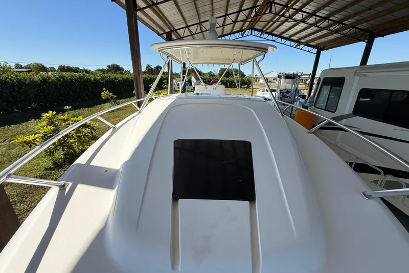 Slide: The Image of 2008 Intrepid 377 Walkaround boat under a metal canopy, surrounded by greenery. - 43