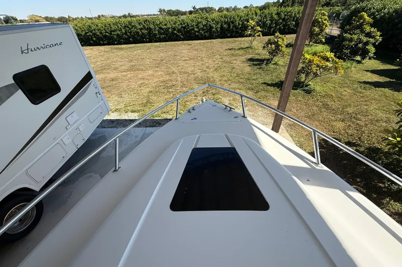 Slide: The Image of 2008 Intrepid 377 Walkaround boat beside a parked RV in a grassy area. - 56