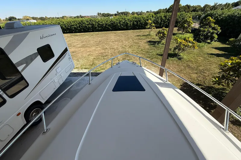 Slide: The Image of 2008 Intrepid 377 Walkaround boat beside a parked RV in a grassy yard. - 58