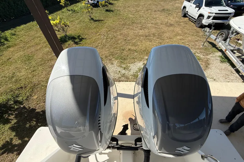 Slide: The Image of Twin Suzuki outboard engines on a 2008 Intrepid 377 Walkaround boat, parked near trucks. - 70