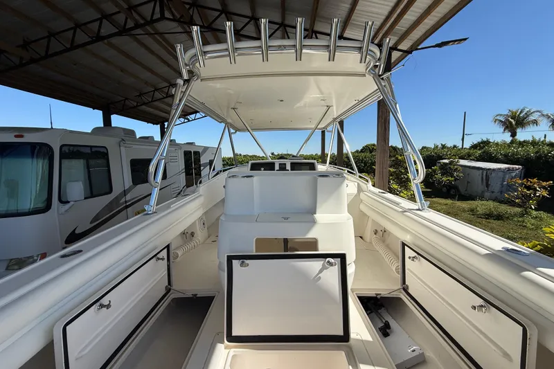 Slide: The Image of 2008 Intrepid 377 Walkaround boat interior with open storage compartments under a canopy. - 74