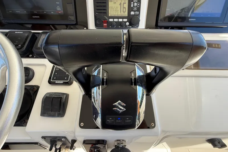 Slide: The Image of Throttle controls on a 2008 Intrepid 377 Walkaround boat dashboard with Suzuki branding. - 96