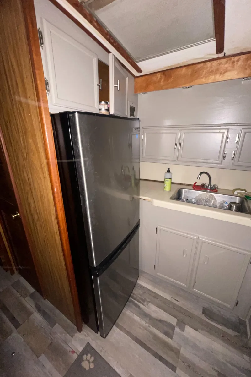 Slide: The Image of 1979 Viking 43 Double Cabin kitchen with stainless steel fridge and gray cabinets. - 15