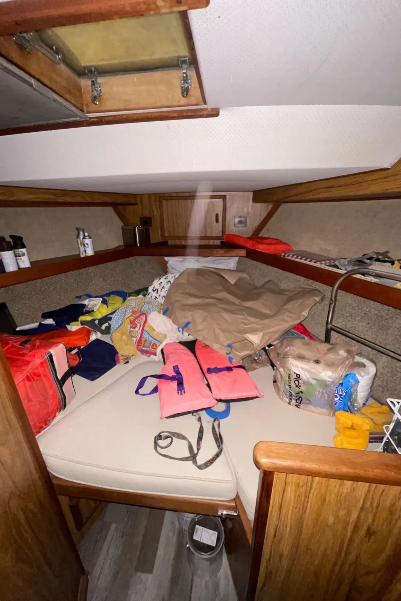 Slide: The Image of 1979 Viking 43 Double Cabin interior with storage items and life jackets on bed. - 17
