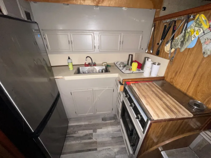 Slide: The Image of 1979 Viking 43 Double Cabin kitchen with stove, sink, and refrigerator. - 7